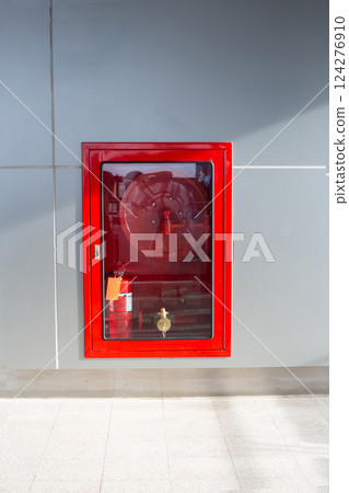 Wall-mounted fire hose cabinet with a glass door 124276910