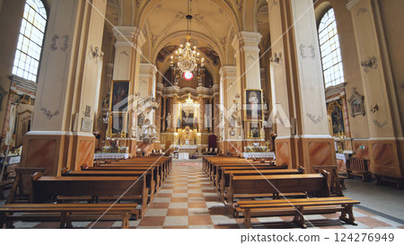 Interior of a church with wooden benches, altar, religious paintings and chandeliers, perfect location for wedding ceremonies 124276949