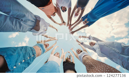 School friends joining hands in a circle, raising arms in celebration of their unity and friendship School friends joining hands in a circle, raising arms in celebration of their unity and friendship 124277136