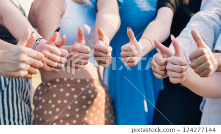 School friends showing unity and teamwork while celebrating shared success with smiles and thumbs up in an outdoor setting School friends showing unity and teamwork while celebrating shared success with smiles and thumbs up in an outdoor setting 124277144