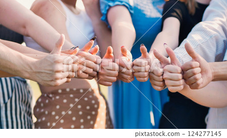 School friends celebrating their agreement and success with smiles and thumbs up in a joyful moment of unity 124277145