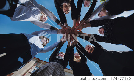 Students joining hands in a circle, representing unity, friendship, and school day happiness 124277150