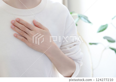 A woman holding her hand on her chest 124277210