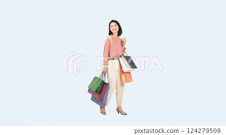Full-body photo of a middle-aged woman walking with a shopping bag 124279509