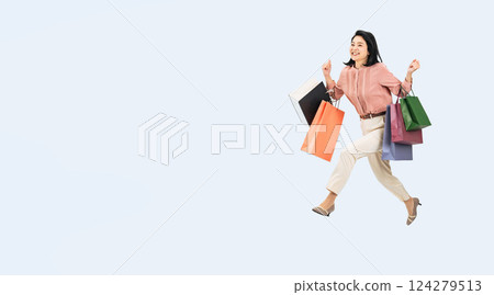 一名中年婦女提著購物袋跳躍的全身照片 124279513