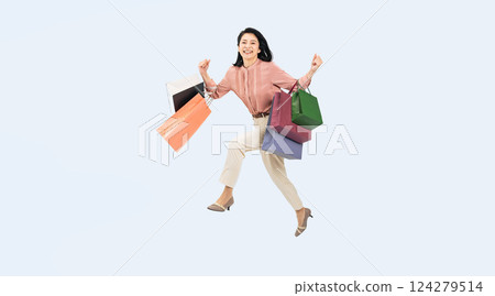 一名中年婦女提著購物袋跳躍的全身照片 124279514