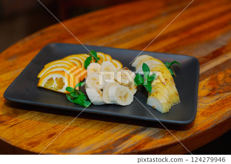 Beautifully chopped fruits on a black plate Beautifully chopped fruits on a black plate 124279946