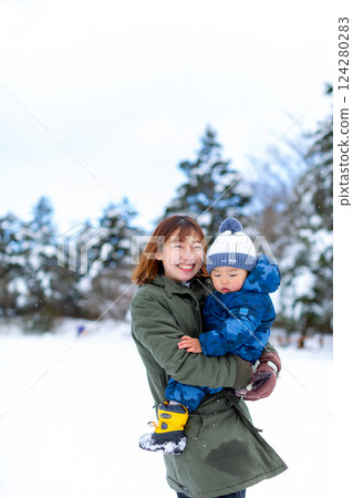 Parent and child playing in the snow 124280283