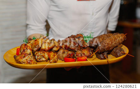 Shish kebab from different types of meat lies on a 124280621