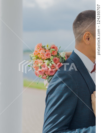 Beautiful young bride holding a bouquet in her 124280707