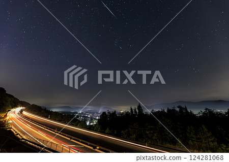 Starry sky in the mountain village, light trails on the highway and Orion 124281068