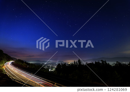 Twilight starry scenery in a mountain village, the light trail on the highway and the Orion constellation 124281069