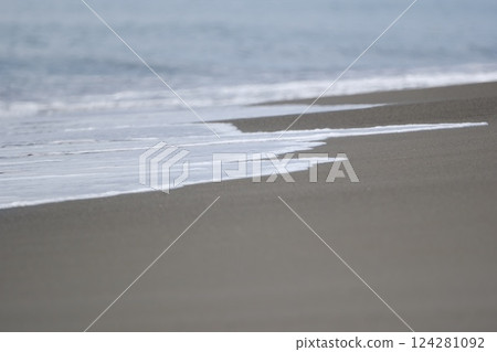浪尖上的泡沫拍打著沙灘 124281092