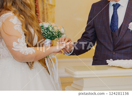 A young beautiful bride puts a ring on her groom's A young beautiful bride puts a ring on her groom's 124281136