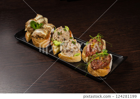 Three types of bruschetta on the table on a black Three types of bruschetta on the table on a black 124281199