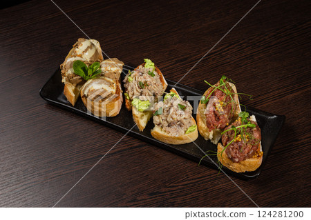 Three types of bruschetta on the table on a black Three types of bruschetta on the table on a black 124281200