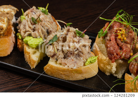 Three types of bruschetta on the table on a black Three types of bruschetta on the table on a black 124281209