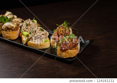 Three types of bruschetta on the table on a black Three types of bruschetta on the table on a black 124281212