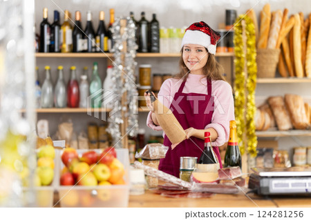 Salesgirl in Santa hat recommending wine on New Years Eve 124281256