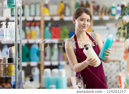 Young woman seller offering shampoo and shower gel Young woman seller offering shampoo and shower gel 124281257