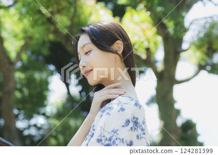 A woman who takes a deep breath at a park 124281399