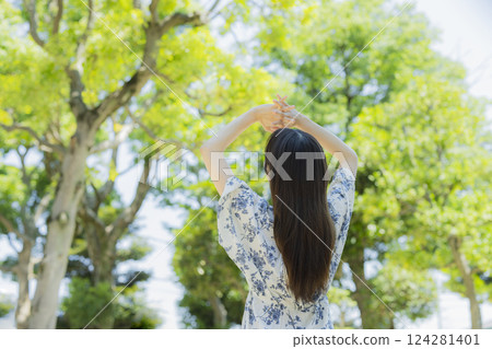 A woman who takes a deep breath at a park 124281401