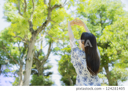 A woman who takes a deep breath at a park A woman who takes a deep breath at a park 124281405