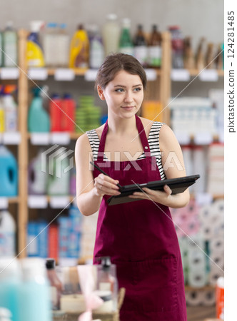 Girl seller, using tablet make inventory in household chemistry store Girl seller, using tablet make inventory in household chemistry store 124281485