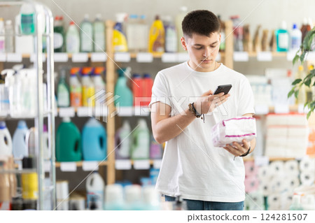 Checking expiration date of feminine pads - male shopper scans QR code on label of feminine pads using smartphone Checking expiration date of feminine pads - male shopper scans QR code on label of feminine pads using smartphone 124281507