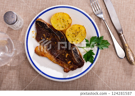 Grilled veal ribs churrasco with baked potatoes and greens Grilled veal ribs churrasco with baked potatoes and greens 124281587