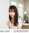 可愛的日本年輕女性，有著長長的棕色波浪髮、自然的妝容和白色短袖上衣 124281654
