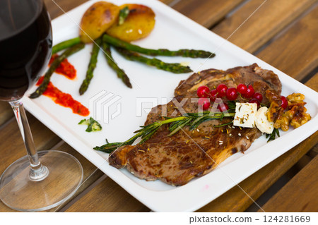 Grilled veal loin with vegetables and redcurrant on wooden background 124281669
