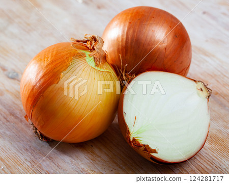 Image of cut onion bulbs on wooden background 124281717