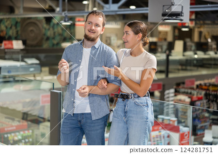 Couple man and woman looking around in building store Couple man and woman looking around in building store 124281751