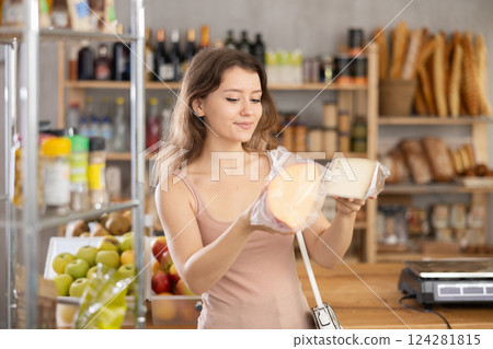 Young woman choosing cheese in grocery store Young woman choosing cheese in grocery store 124281815