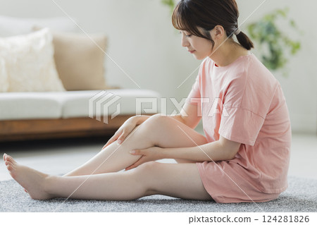 A woman in pajamas doing body care 124281826