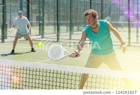 Two adult men playing doubles padel 124281827