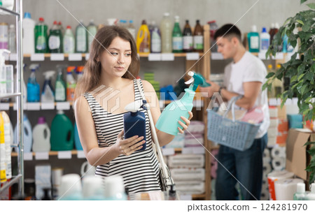 Girl view trademark sign on label, pick eco friendly glass cleaner, man shopping in background 124281970
