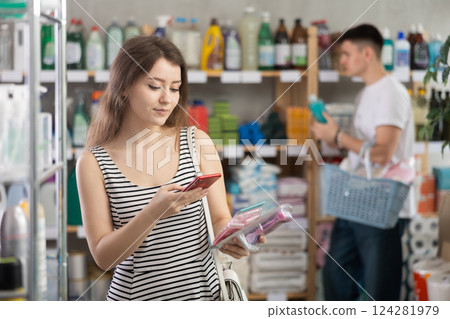 Girl buyer scans qr code on razor label, man shopping in background Girl buyer scans qr code on razor label, man shopping in background 124281979