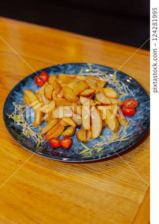 Rustic fried potatoes with fresh tomatoes on a Rustic fried potatoes with fresh tomatoes on a 124281995