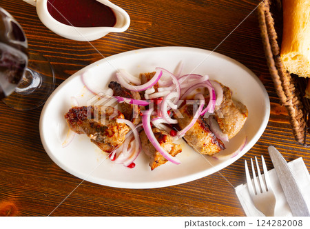 Grilled pork meat shashlik with marinated onion 124282008