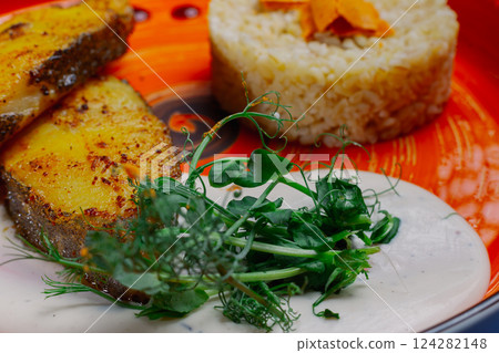 Grilled fresh red fish lies on a plate along with Grilled fresh red fish lies on a plate along with 124282148