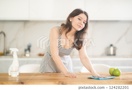 Young woman wiping table with rag 124282201