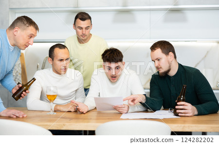 Group of men supporting troubled friend reading legal notice 124282202