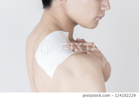 Man applying a compress to his shoulder, shoulder pain, stiff shoulders, compress, muscle pain Man applying a compress to his shoulder, shoulder pain, stiff shoulders, compress, muscle pain 124282229
