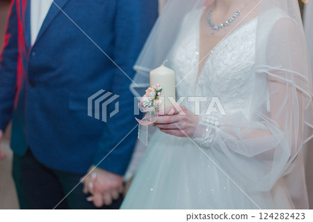 The wedding candle in the hands of the bride and The wedding candle in the hands of the bride and 124282423