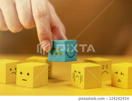 Customer Experiences Concept. Hand Picking a Five Star Review. a Smiling Happy Cube Stand Out among many Negative Feedback Customer Experiences Concept. Hand Picking a Five Star Review. a Smiling Happy Cube Stand Out among many Negative Feedback 124282914