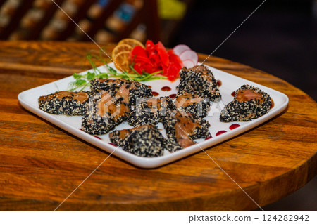 Grilled red fish meat with sesame seeds. Plate 124282942