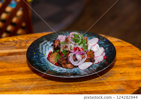 Grilled meat with baked vegetables on a plate on a 124282944