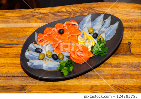 Sliced two varieties of fish with greens, lemon 124283755